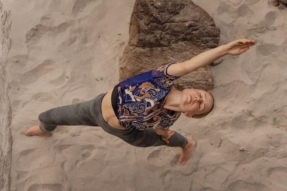 a woman standing in the sand with a frisbee