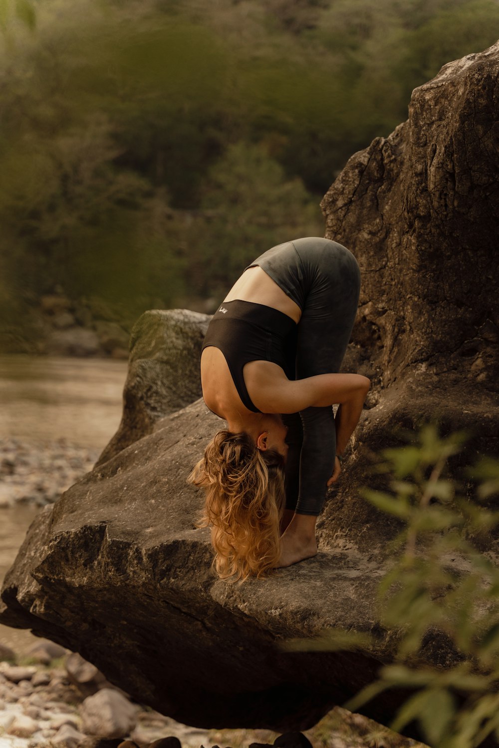 a woman is doing a handstand on a rock