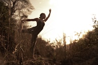 A serene outdoor scene with Marta performing a ritual at dawn surrounded by nature.