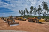 A fleet of dump trucks lined up ready for debris removal after a construction project