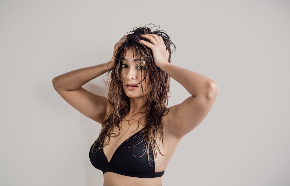 a woman with wet hair in a black bikini