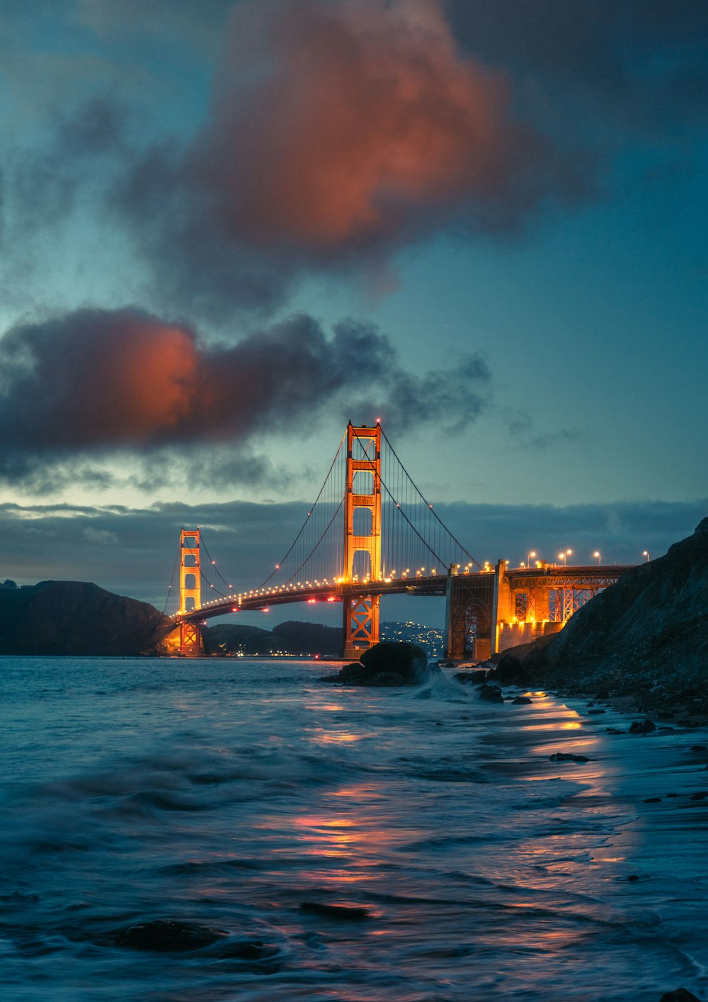 the golden gate bridge is lit up at night