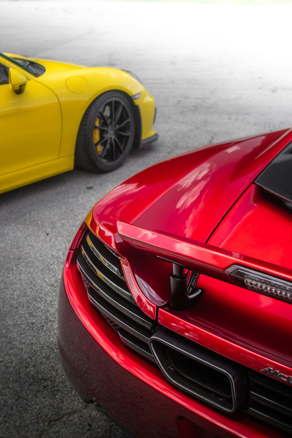 a red sports car parked next to a yellow sports car