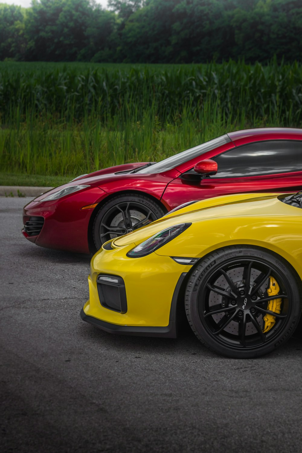 two red and yellow sports cars parked in a parking lot