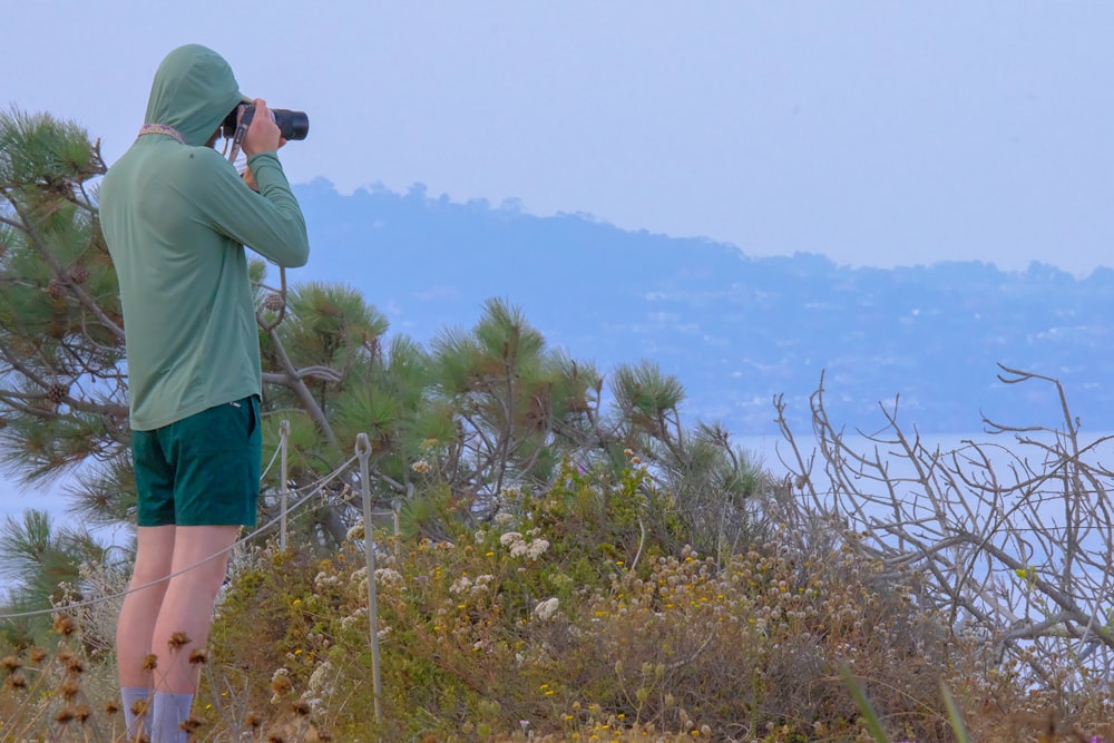 a man taking a picture of a mountain with a camera