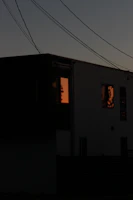 A sleek hybrid power system installed beside a modern home, glowing softly at dusk.