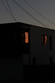 A modern home powered by solar panels glowing warmly at dusk.
