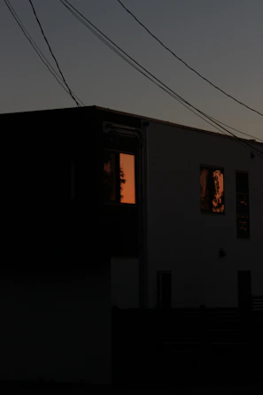 A sleek hybrid power system installed beside a modern home, glowing softly at dusk.