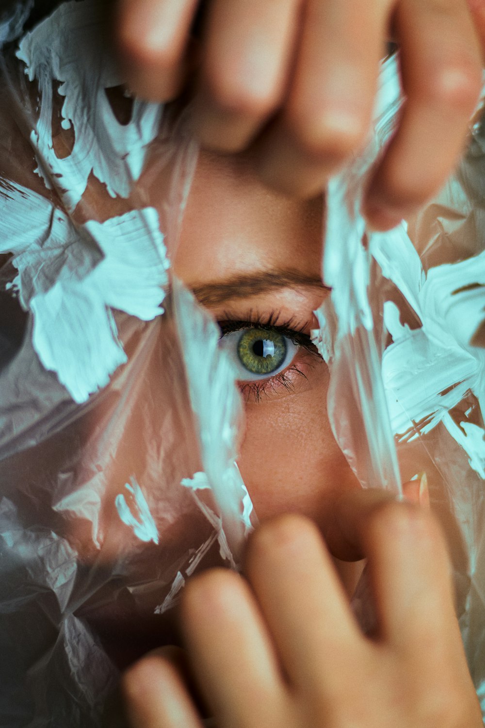 a woman with green eyes is wrapped in plastic