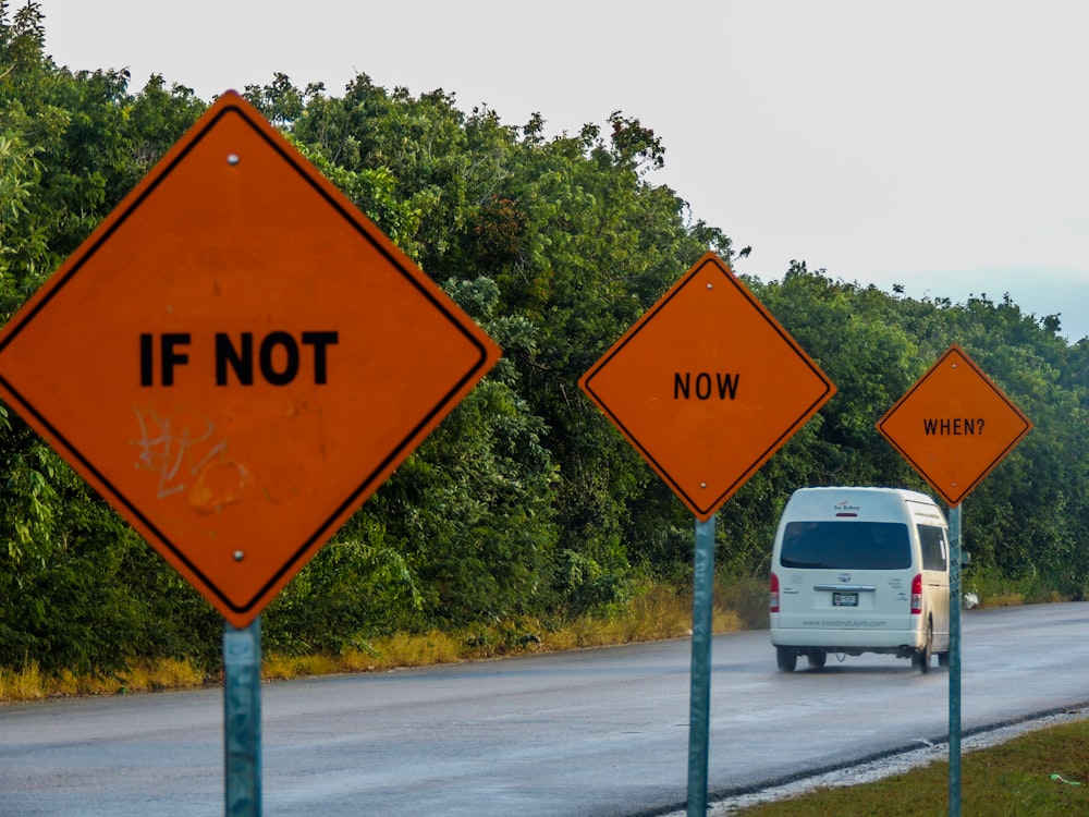 a van driving down a road next to a forest