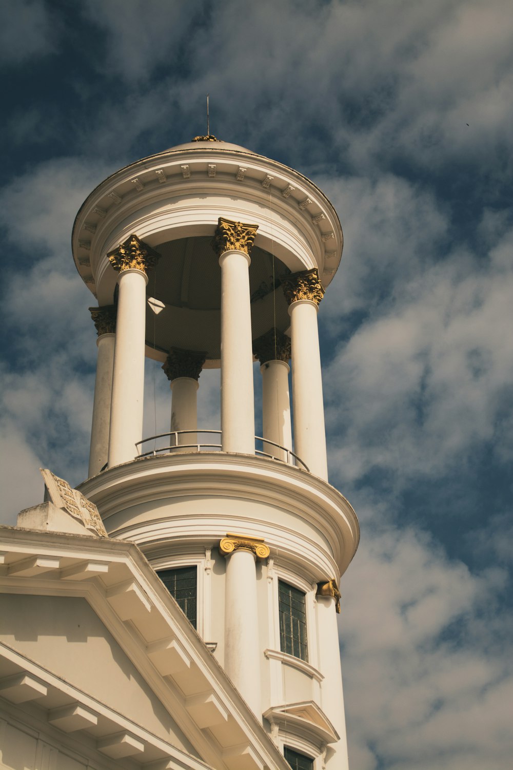 a tall white building with a clock on it's side