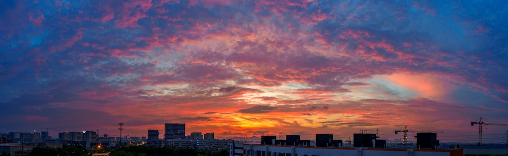 a colorful sunset over a city with tall buildings