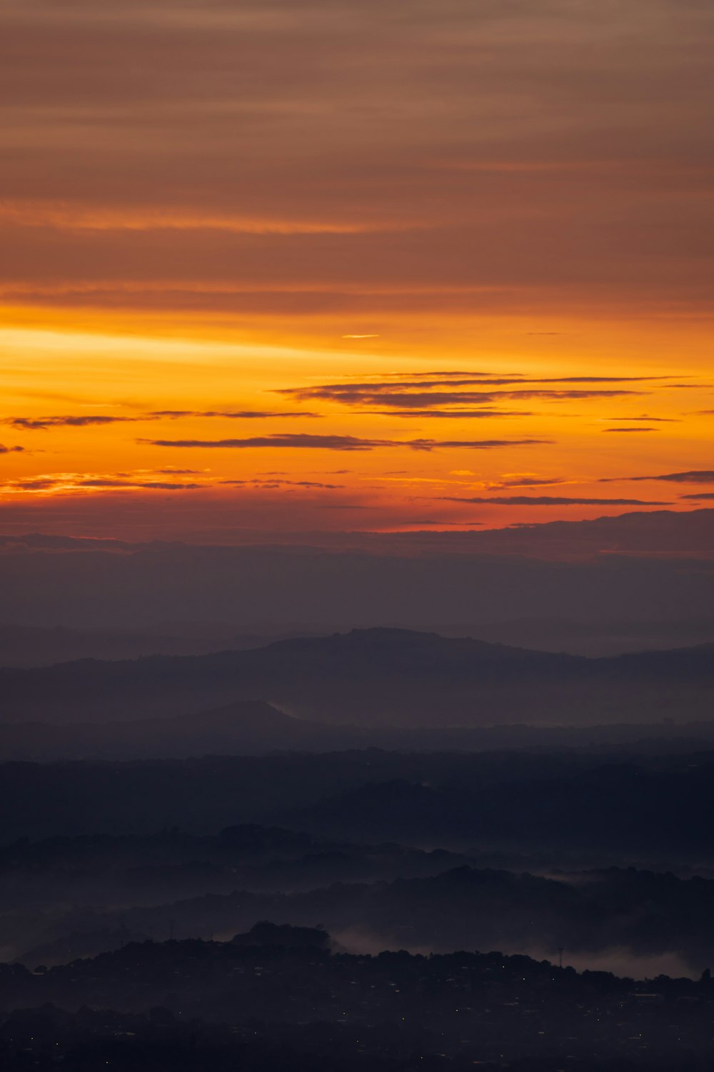 the sun is setting over the mountains in the distance