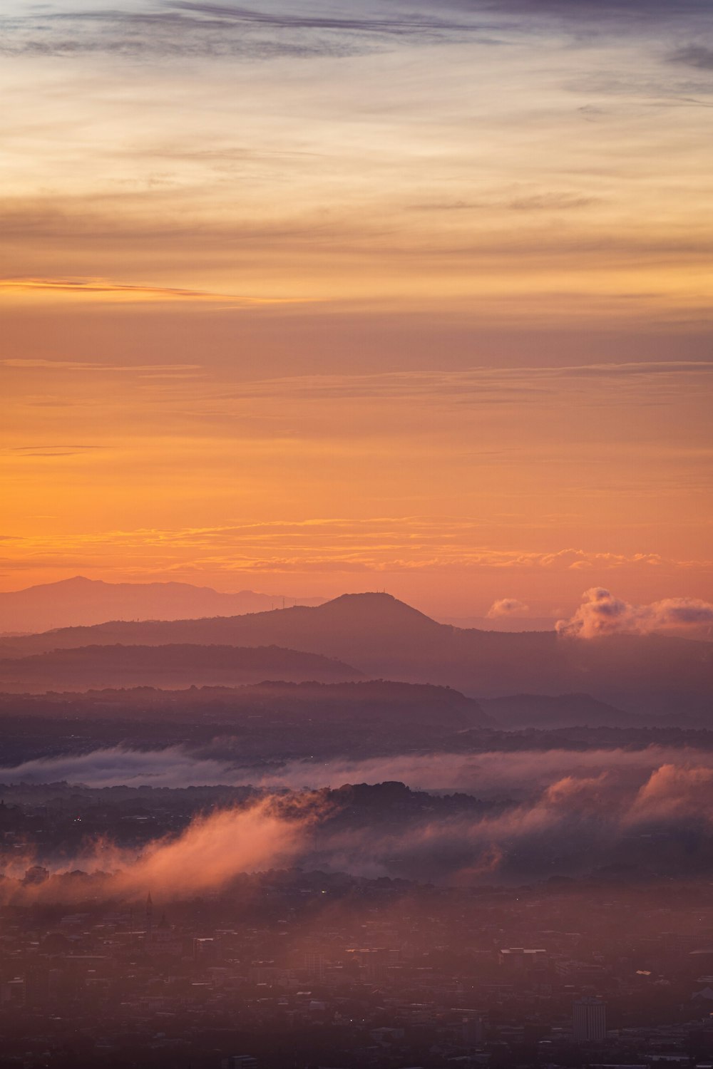 the sun is setting over a mountain range