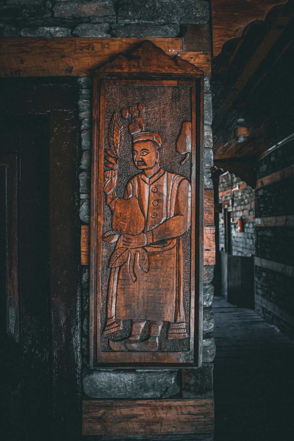 a wooden carving of a man holding a bird