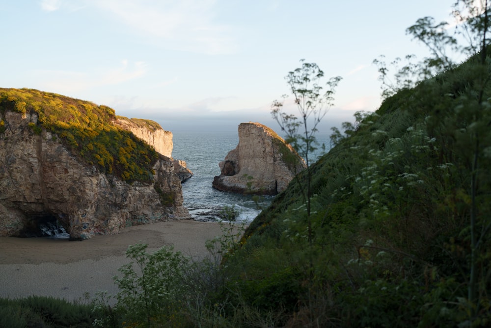 a large rock formation on a beach next to the ocean