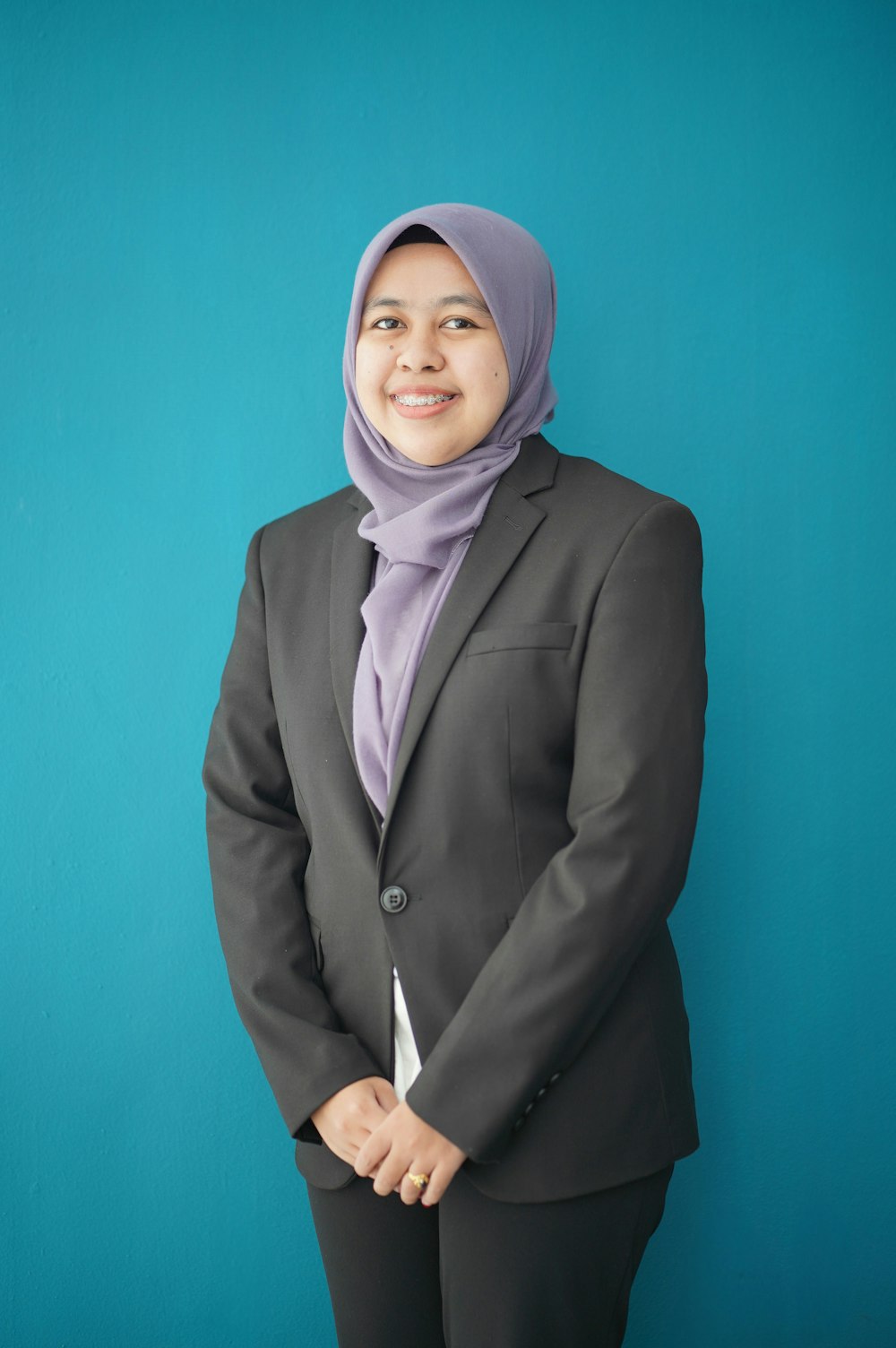 Una donna in giacca e cravatta e hijab in posa per una foto