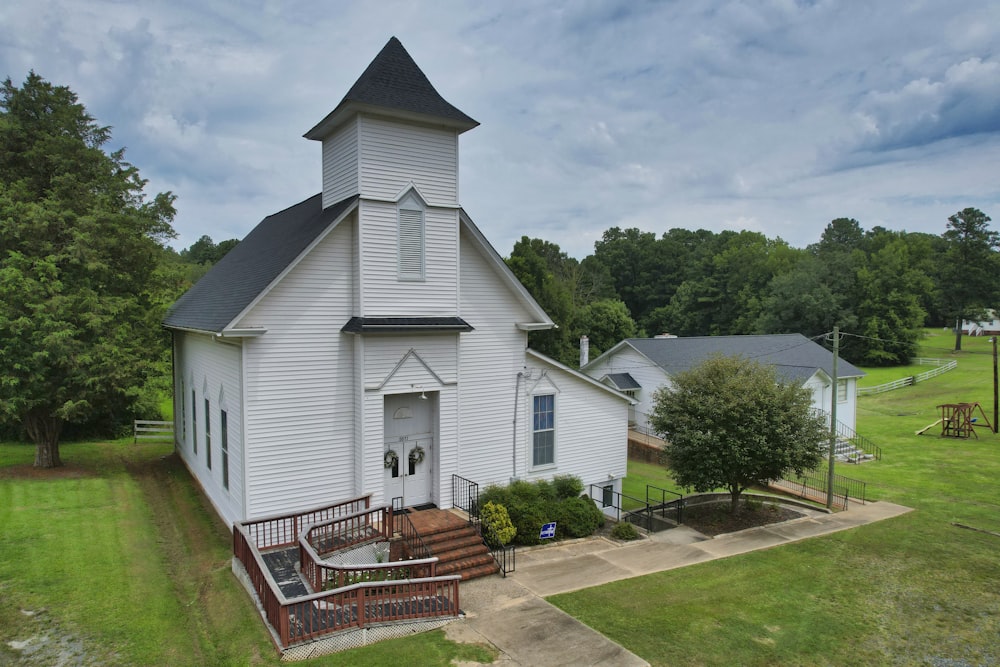 a white church with a steeple and stairs