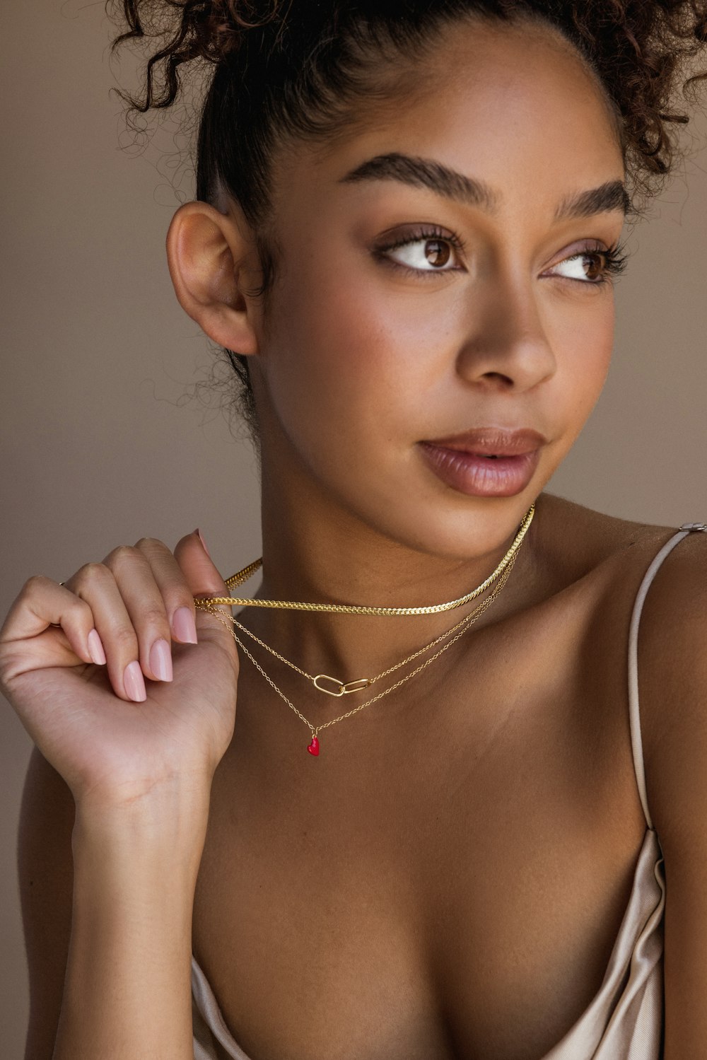 a woman wearing a necklace with a red heart on it