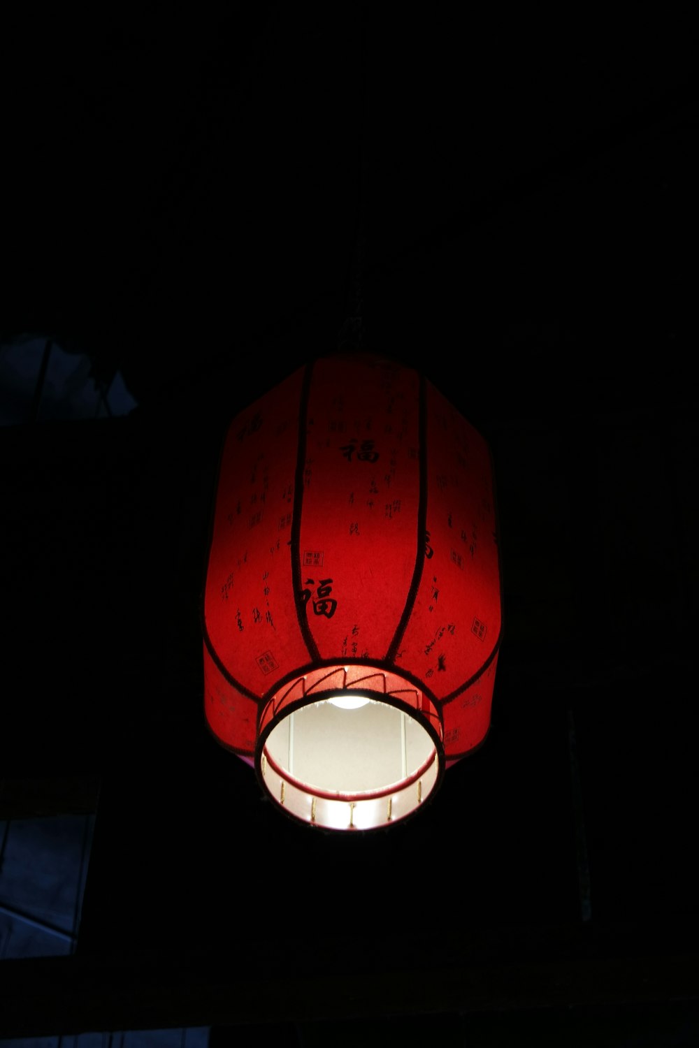 a red lamp hanging from the ceiling in a dark room
