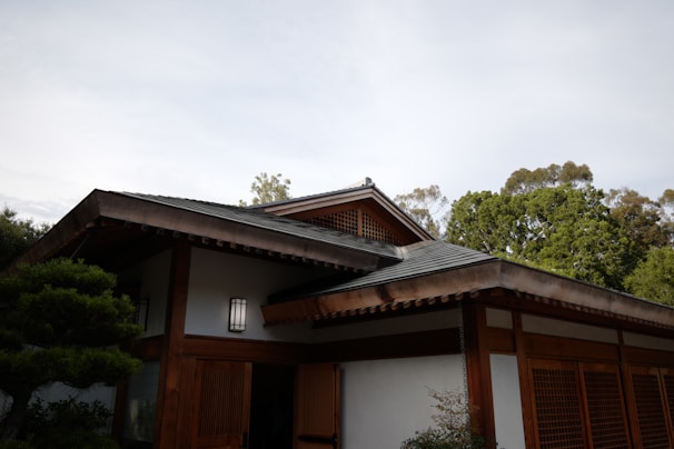 A serene tropical building with wooden accents nestled among lush greenery in Lombok.