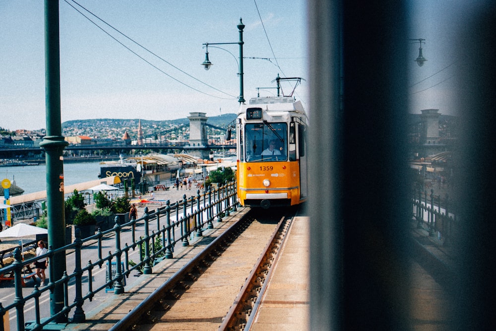 un train jaune et blanc circulant sur les voies ferrées