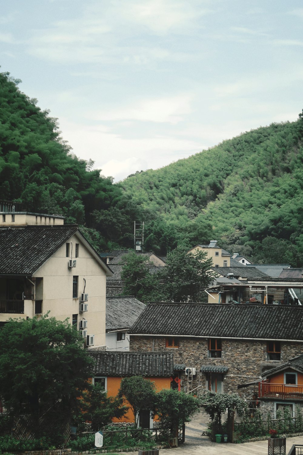 a group of buildings sitting on top of a lush green hillside