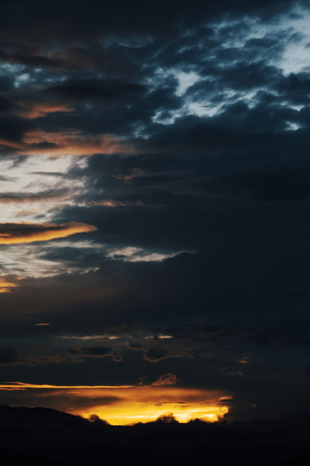 Un avion volant dans un ciel nuageux au coucher du soleil