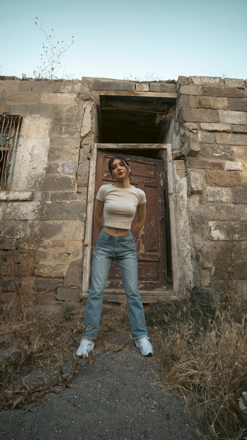 a woman standing in front of a brick building