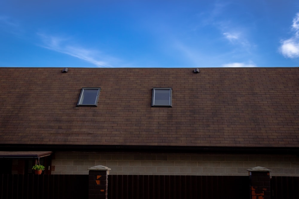 a house with two windows and a brown roof