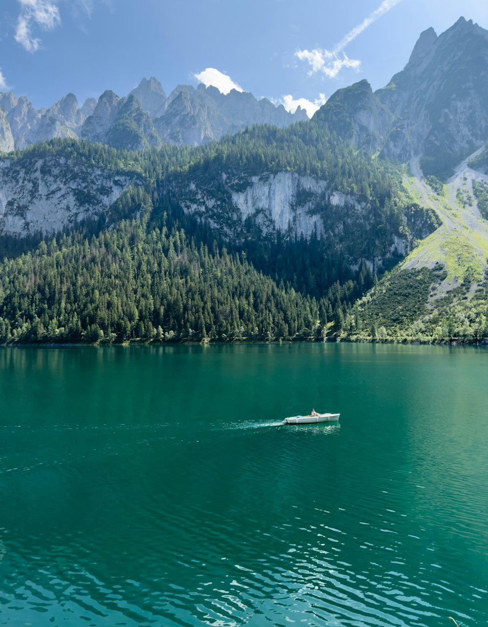 a boat in the middle of a lake with mountains in the background