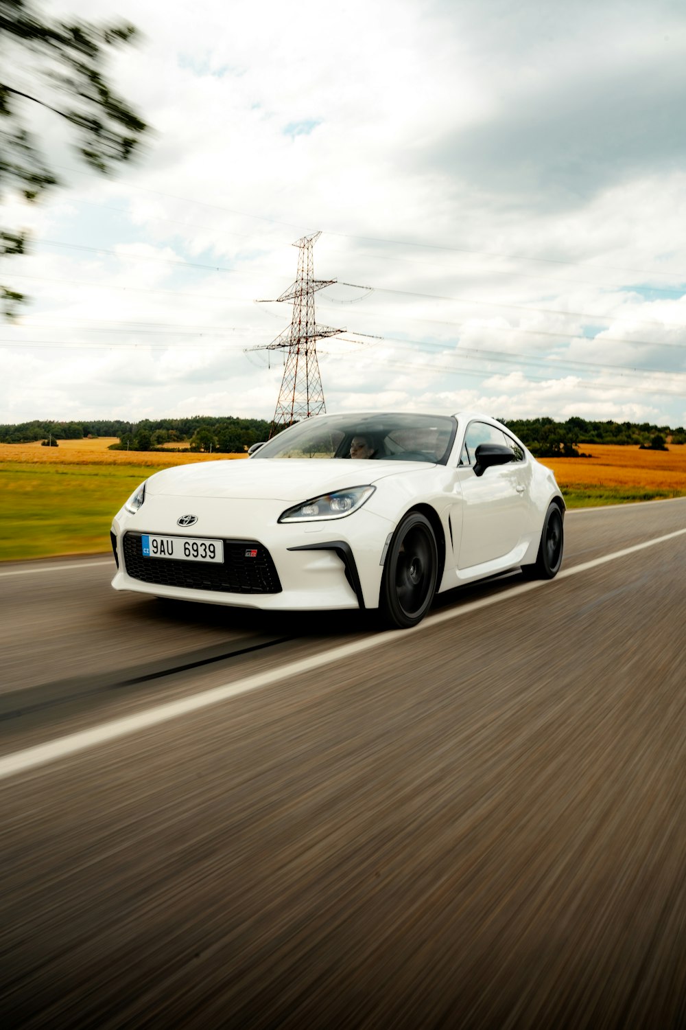 a white sports car driving down the road