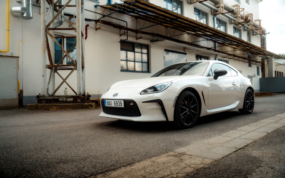 a white sports car parked in front of a building