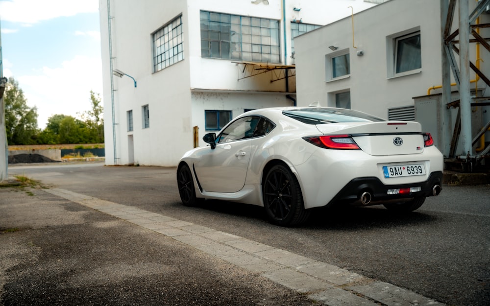 a white sports car parked in front of a building