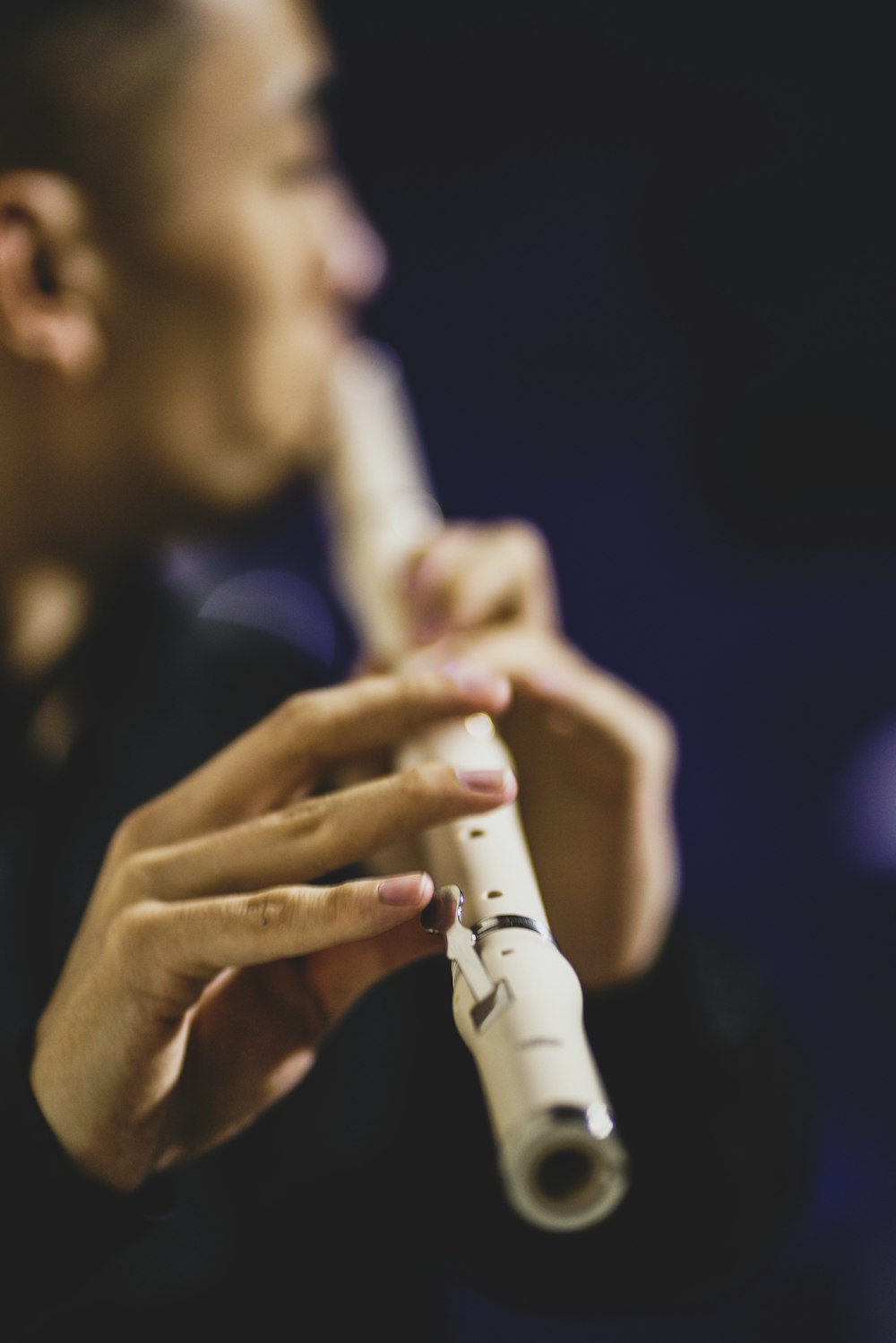 a man playing a flute in a dark room