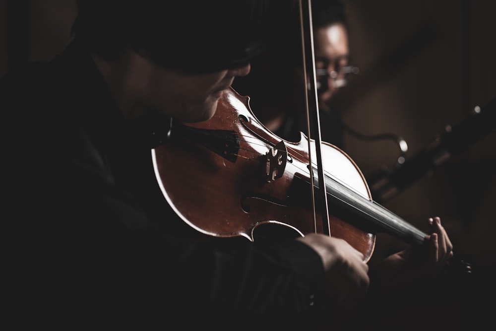 a man playing a violin in a dark room