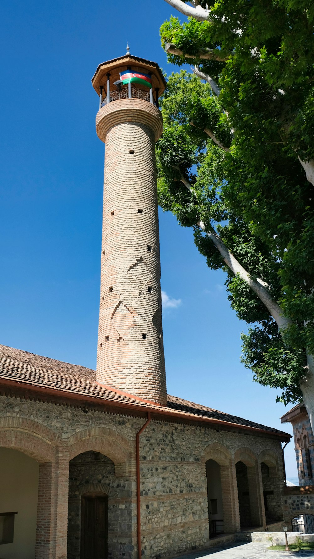 una alta torre de ladrillo con un reloj en su lado