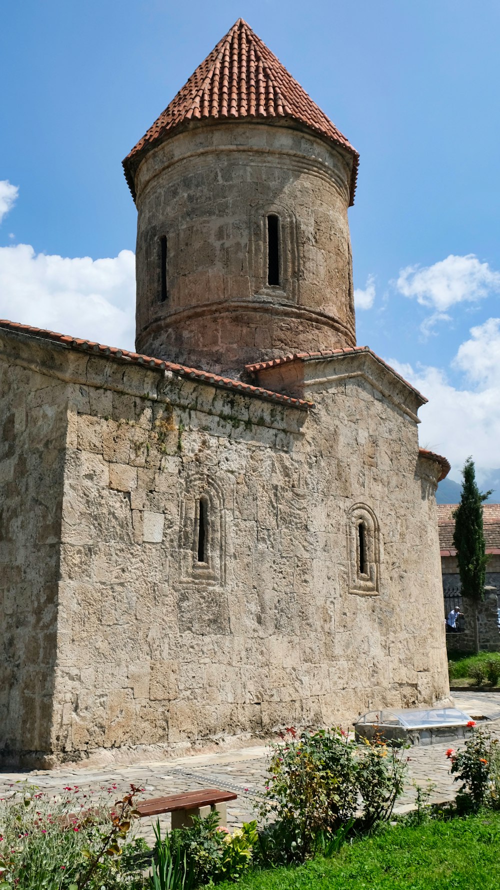 a stone building with a red tiled roof