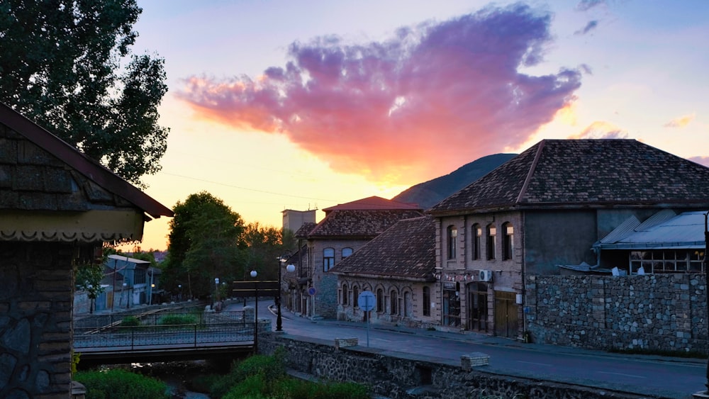 the sun is setting over a small village