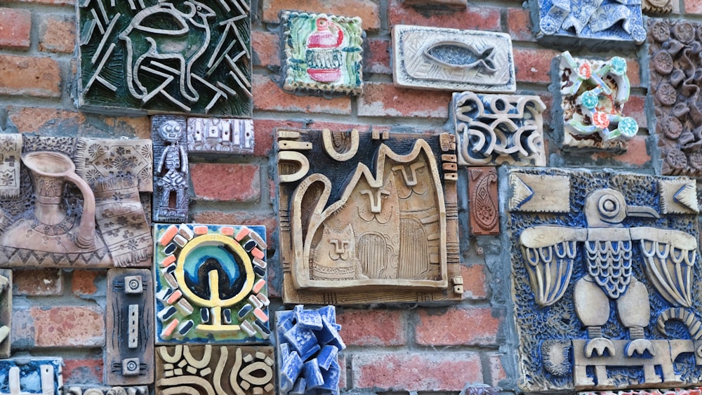 a brick wall covered in different types of decorative tiles