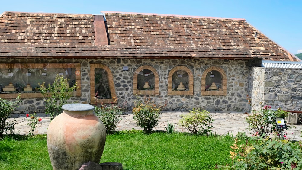 a large vase sitting in front of a stone building