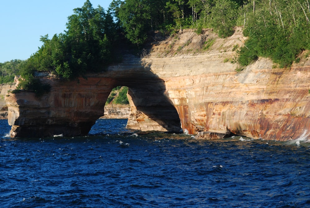 a large rock formation in the middle of a body of water