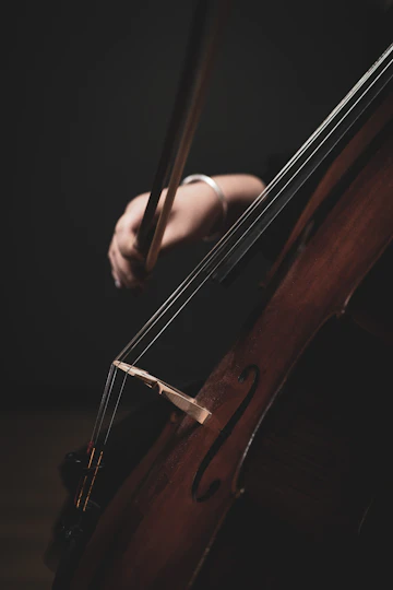 Cellist performing on a dark stage