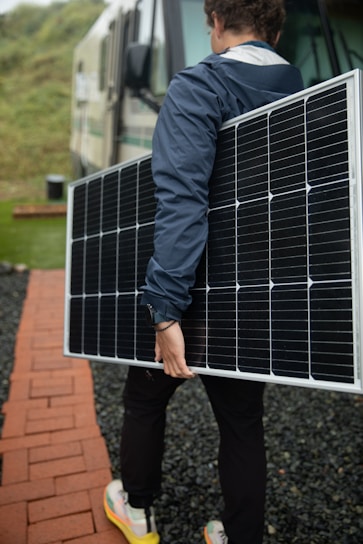 a man carrying a solar panel on his back