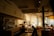 A cozy café with people enjoying their drinks and chatting happily.