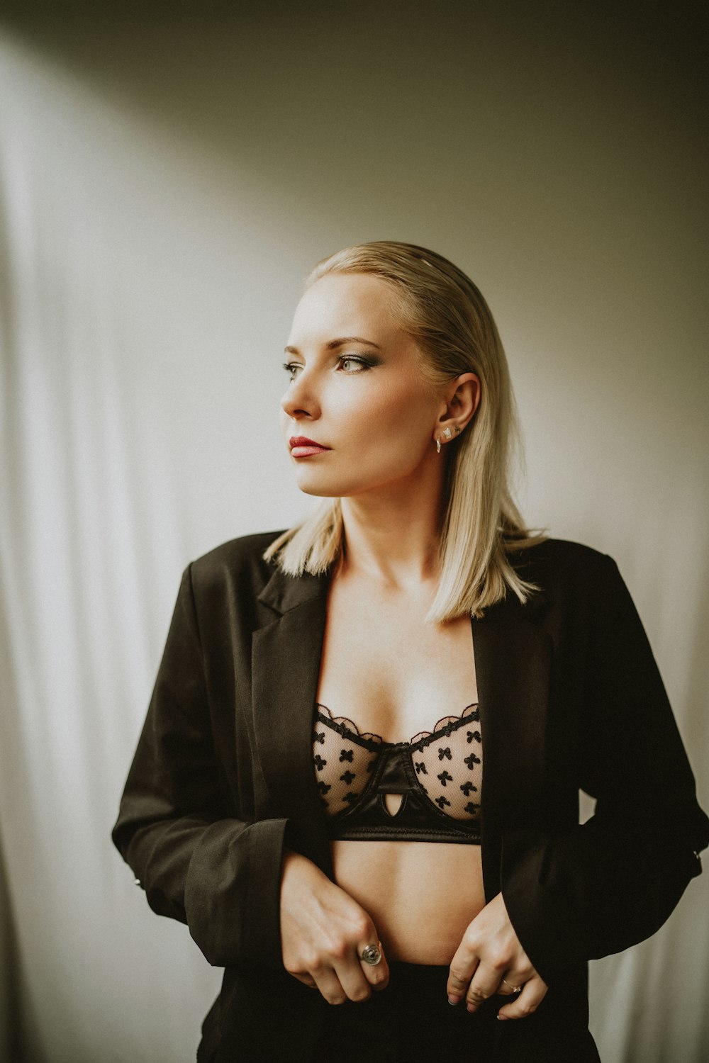 a woman in a black suit and polka dot bra