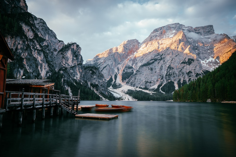 a lake with a dock and mountains in the background