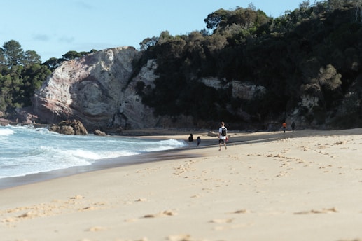 a group of people standing on top of a sandy beach
