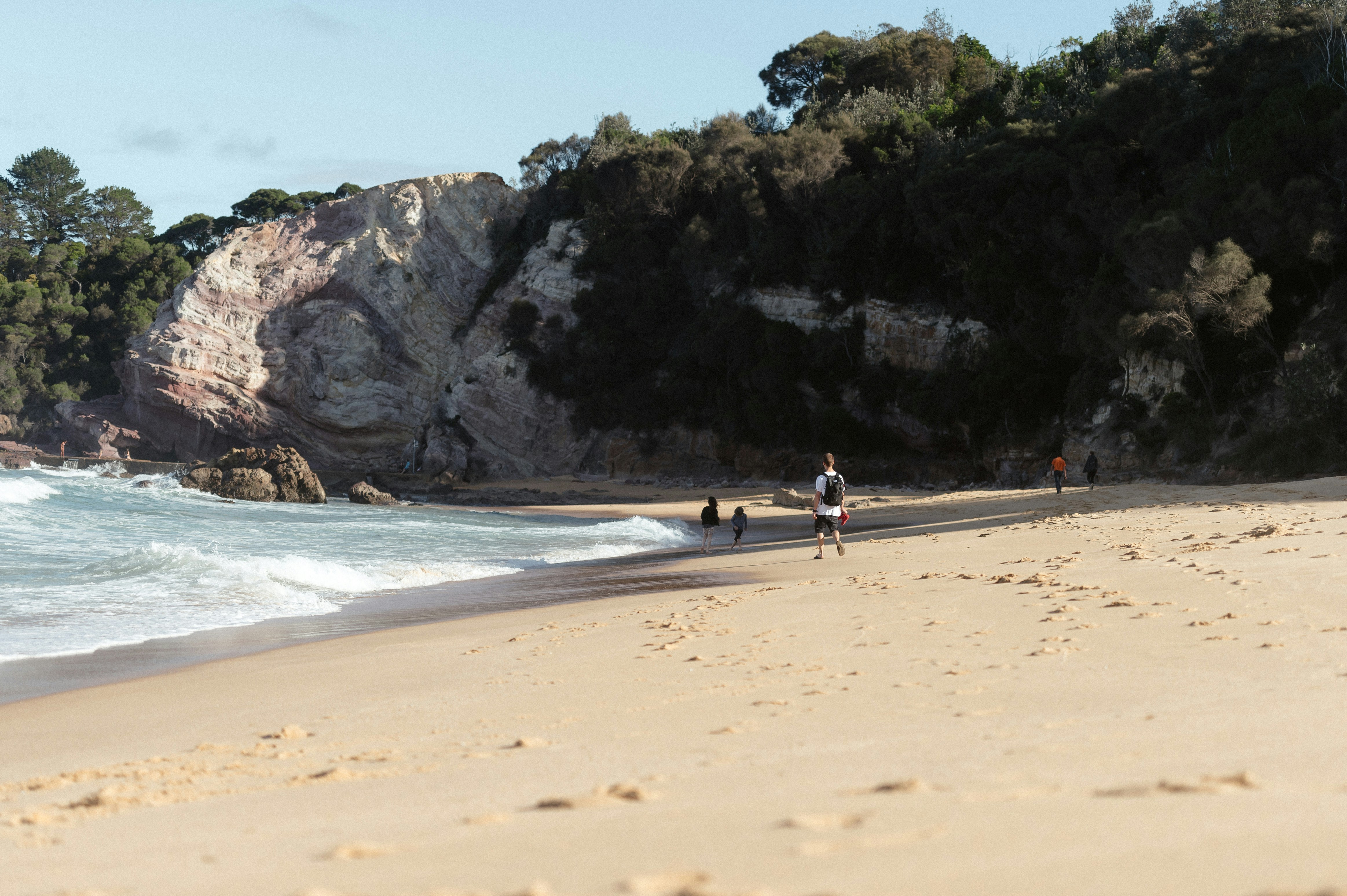 a group of people standing on top of a sandy beach