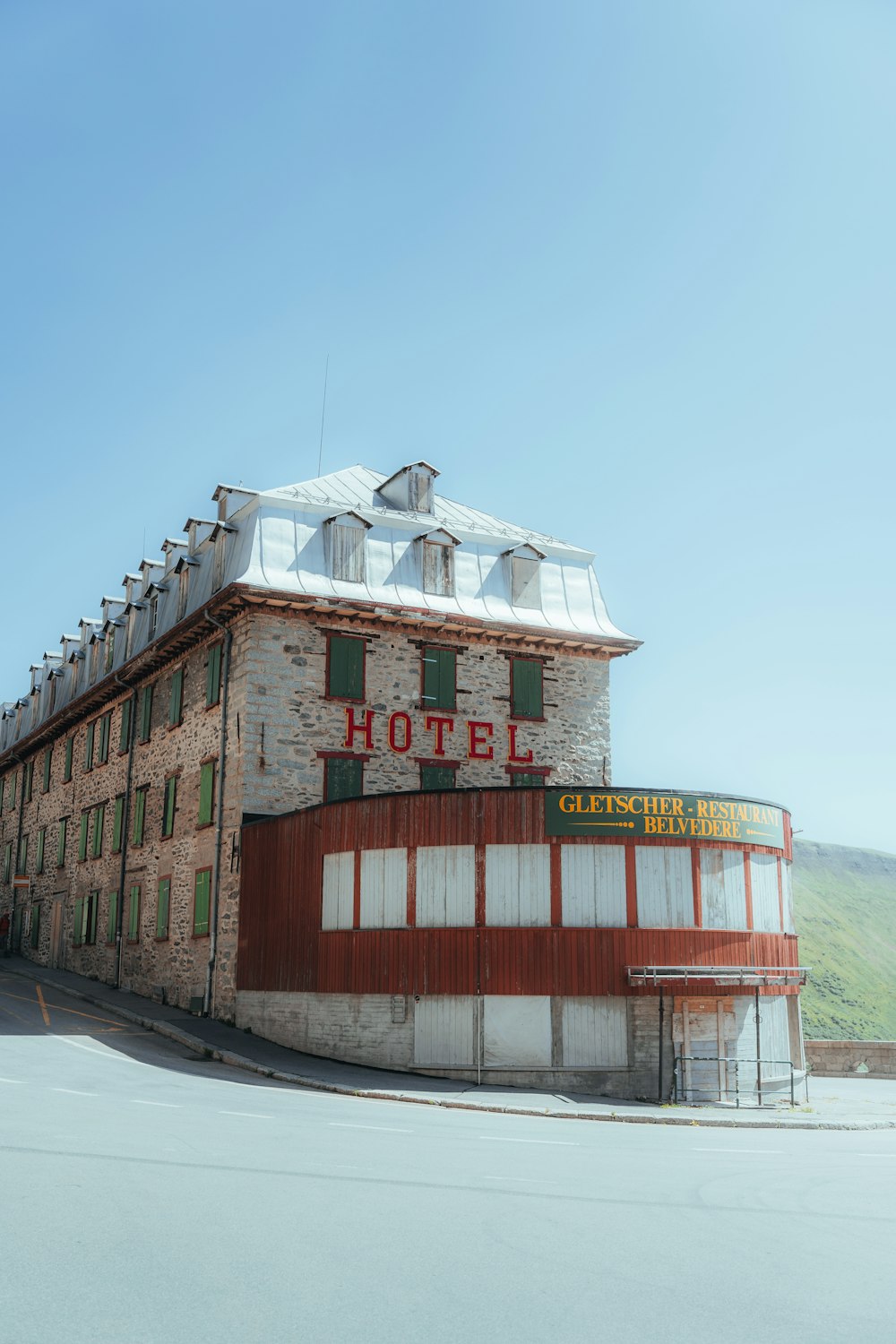 un grand bâtiment en briques assis sur le bord d’une route